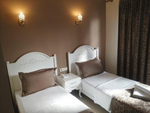 a bedroom with two beds and a nightstand and two beds sidx sidx at Enda Boutique Hotel Kalkan in Kalkan