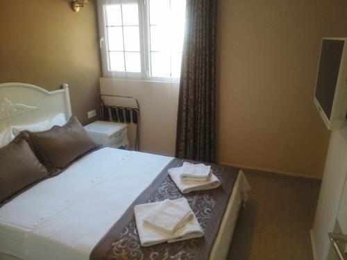 a bedroom with a bed with two towels on it at Enda Boutique Hotel Kalkan in Kalkan