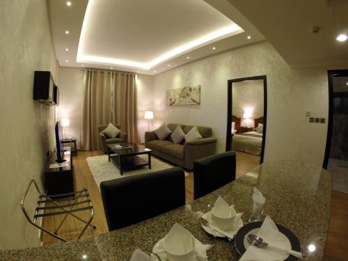 sala de estar con sofá y mesa en una habitación en Le Park Hotel, en Doha