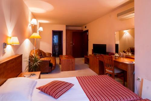 a hotel room with a bed and a desk at Plaza Hotel in Varna City