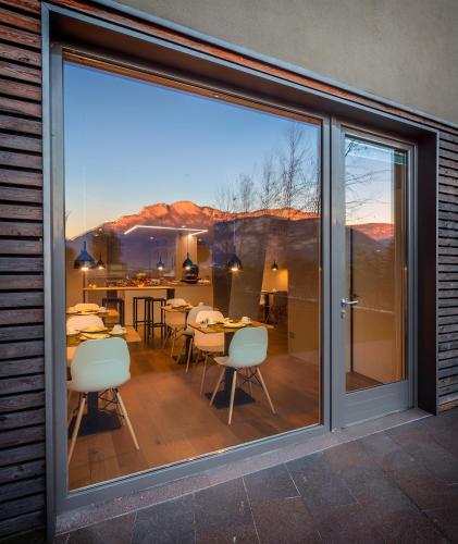 a sliding glass door with a patio with tables and chairs at La Villa - Luxury Guest House in Trento