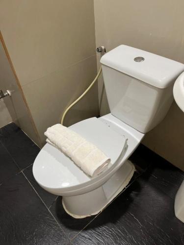 a white toilet in a bathroom with a hose at My place 77 2 in Ban Khlong Khwang Klang