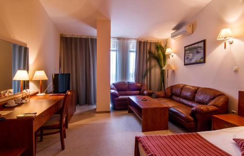 a living room with a couch and a table at Plaza Hotel in Varna City