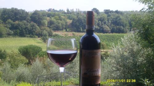 a bottle of wine next to a glass of wine at Le Mimose B&B in Vinci