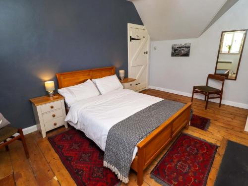 a bedroom with a bed and a table and a chair at Gamekeepers Cottage in Chillingham