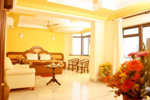 a bedroom with a bed and a living room at Hotel Sun World in Kanyakumari