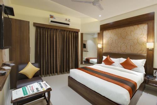 a hotel room with a large bed and a couch at Hotel Heritage - Near Navrangpura in Ahmedabad