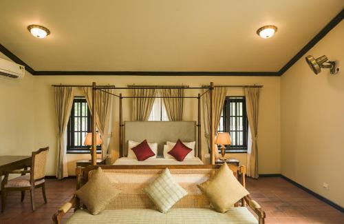 a bedroom with a bed with red pillows at Parisons Plantation Experiences by Abad in Mananthavady
