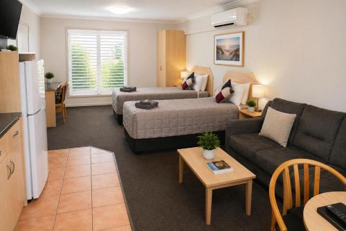 a living room with a couch and a bed at Southern Cross Motor Inn in Narrabri