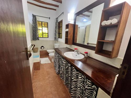 a bathroom with a counter with a sink and a toilet at Fasha House Malindi in Malindi