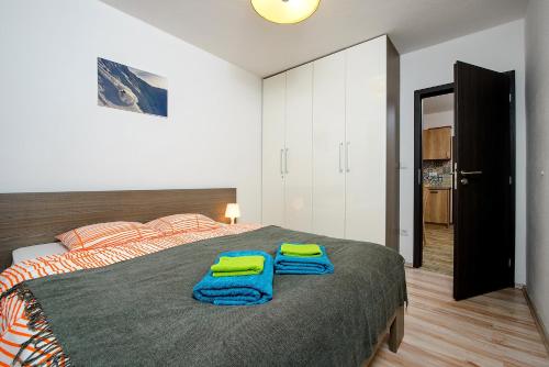 ein Schlafzimmer mit einem Bett mit zwei Handtüchern darauf in der Unterkunft Apartman #11 - Apartmanovy dom Ďumbier - Chopok Juh in Tale