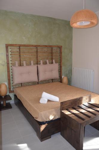 a bedroom with a large bed with a wooden headboard at B&B Albatros in Castelluzzo