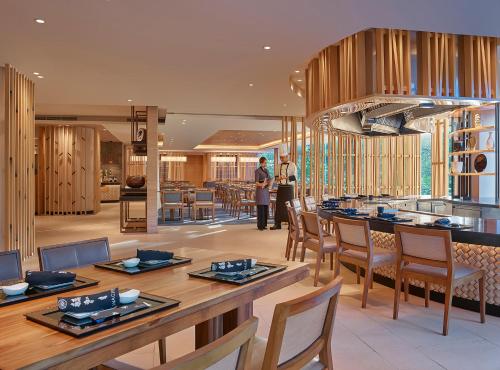 a man standing in a restaurant with a table and chairs at Makati Shangri-La, Manila in Manila