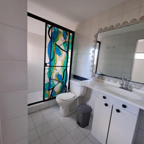 a bathroom with a toilet and a stained glass window at Fortaleza Diosa Chia in Chía