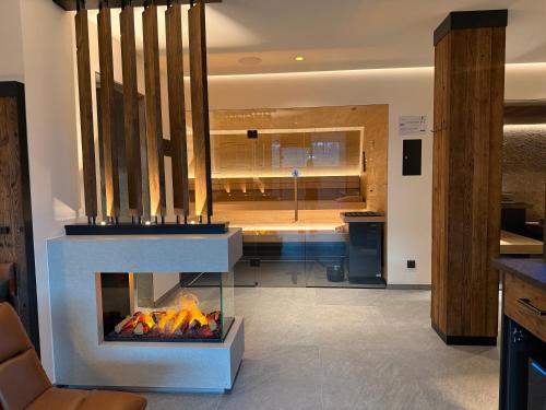 a living room with a fireplace and a kitchen at Hotel Seeblick in Bernried