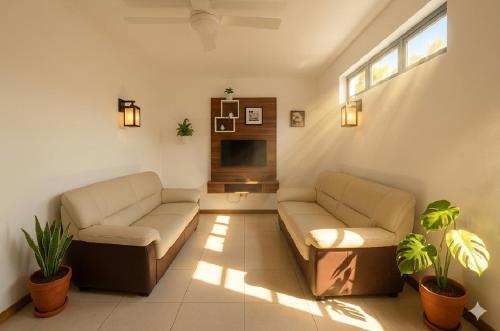 a living room with two couches and a tv at La Nuit Étoilée , Restez plus, payez moins ! in La Gaulette