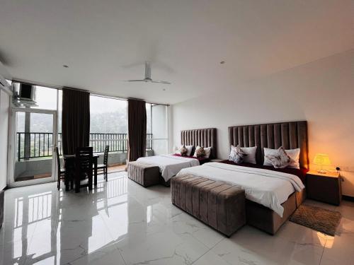 a hotel room with two beds and a couch at Ruish City Kandy in Kandy
