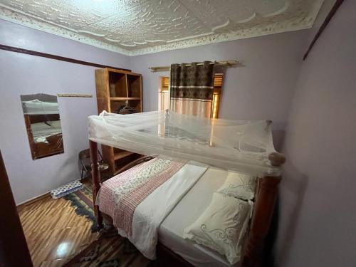 a bedroom with a bed with a canopy at APARTMENT 01 Meadowbrook Home Stade in Kasaayi