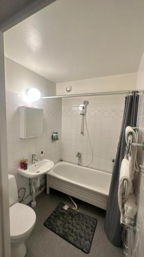 a bathroom with a tub and a toilet and a sink at kenneth's Home in Stockholm
