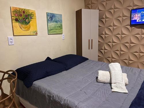 a bedroom with a bed with a tv on the wall at Rosy flat térreo in Petrolina