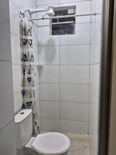 a white bathroom with a toilet and a window at Rosy flat térreo in Petrolina