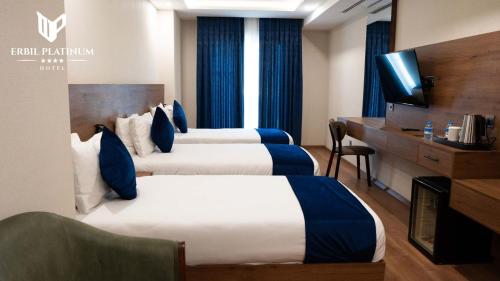 a hotel room with two beds and a television at Erbil Platinum Hotel in Erbil