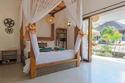 a bedroom with a bed with mosquito nets at Gili Air Bungalows in Gili Islands