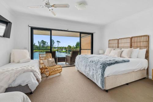 a bedroom with two beds and a view of the water at The Lake House in Mulwala