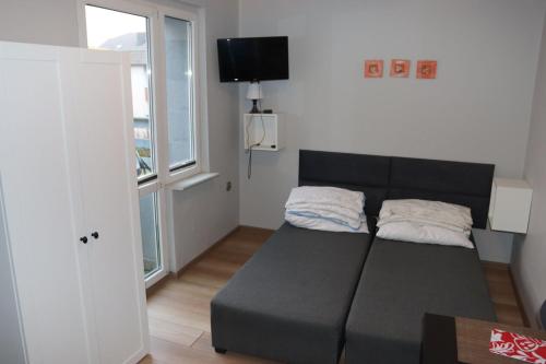a living room with a couch and a window at Minuta do plaży - Sarbinowo in Sarbinowo
