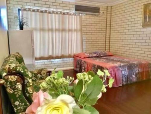 a living room with a couch and a table with flowers at Less pay for master room in Rosewater