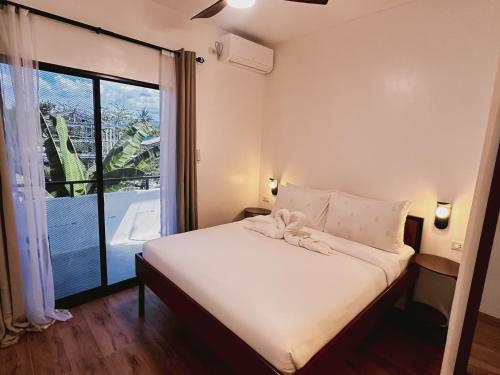 a bedroom with a bed and a large window at Puy-An, A Nomad Hostel in Moalboal