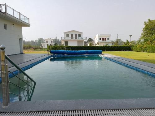 a swimming pool with blue inflatables in front of a house at Corbett Krishna Inn in Belparāo
