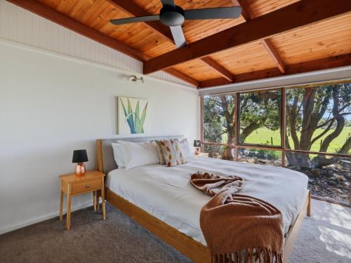 a bedroom with a bed and a ceiling fan at Prom Coast Oasis - Sandy Point in Sandy Point