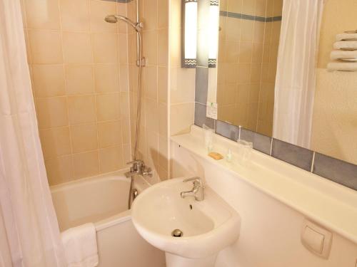 a bathroom with a sink and a toilet and a tub at Campanile Alençon in Alençon