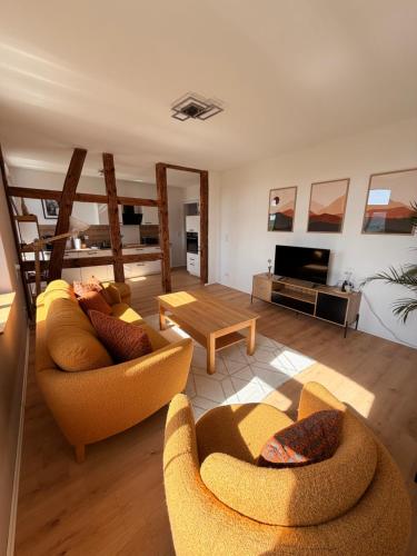 a living room with two couches and a table at HofQuartier Altmersleben in Altmersleben