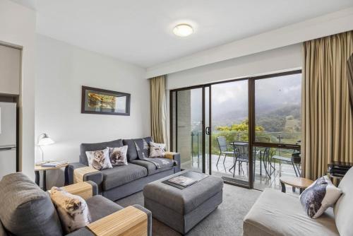 a living room with a couch and a table at Lantern 22 - Balcony in Thredbo