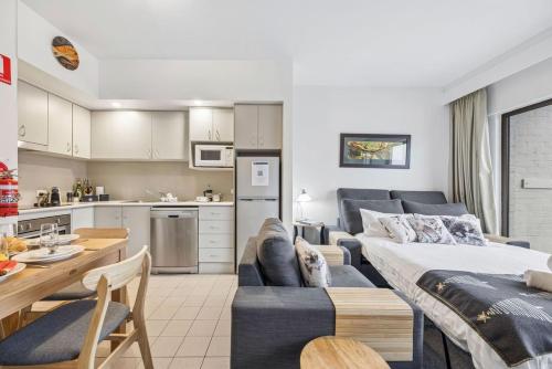 a living room and kitchen with a couch and a table at Lantern 22 - Balcony in Thredbo