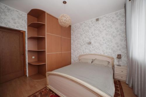 a bedroom with a bed and a book shelf at Apartment na Baumana 26 in Kazan