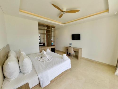 a bedroom with a white bed with a ceiling fan at Rusa by The Lake in Baturiti
