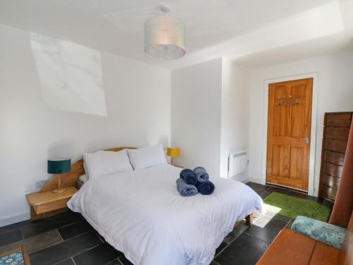 a bedroom with a bed with a teddy bear on it at Gun Powder Cottage in Tighnabruaich
