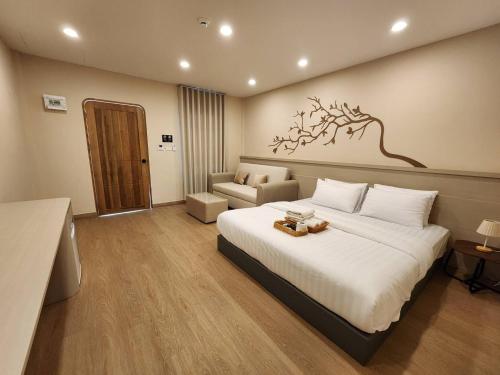 a hotel room with a large bed and a couch at Phusira ภูศิรา กาญจนบุรี in Ban Tha Kilen (1)