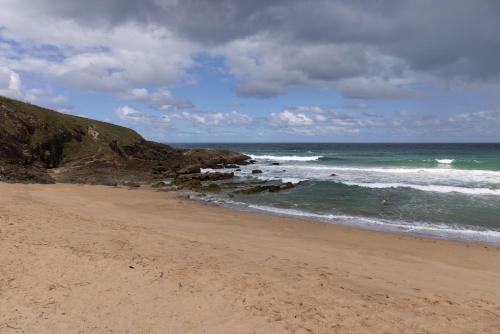 a sandy beach with waves in the ocean at Reflections Moonee Beach - Holiday Park in Moonee Beach