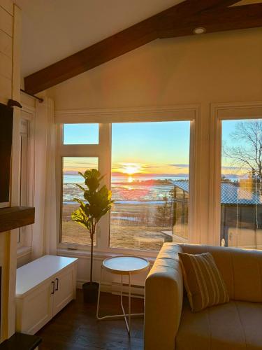a living room with a couch and a large window at L'Anseau-Persil in Rivière-du-Loup