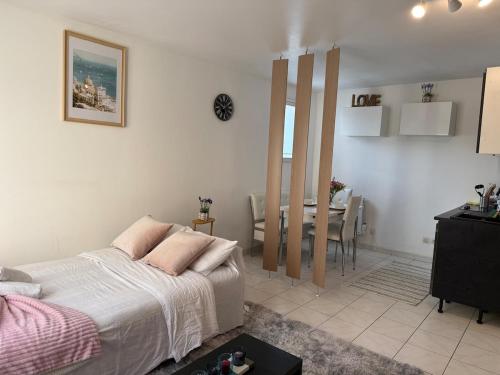 a bedroom with a bed and a dining room at Bienvenue au Nid Rosé in Montereau-Fault-Yonne