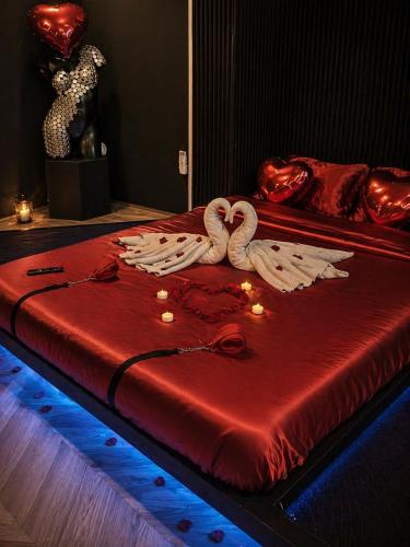 a bed with two swans on top of it at Love Room balnéo double & sauna Privés - Nuit d'exception in Briord