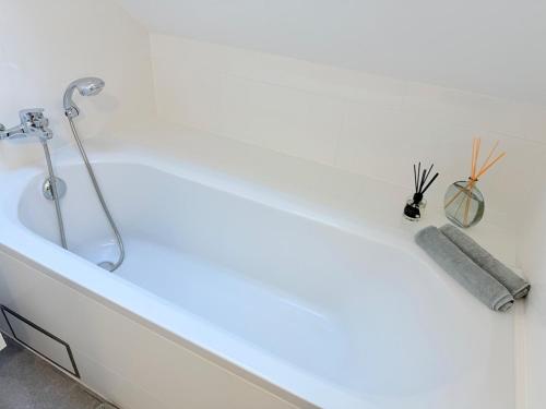 a white bath tub with a light on it at TRIPLEX 2 chambres Cosy à MONS in Mons