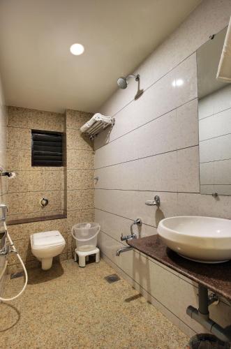 a bathroom with a sink and a toilet at Hotel Heritage - Near Navrangpura in Ahmedabad