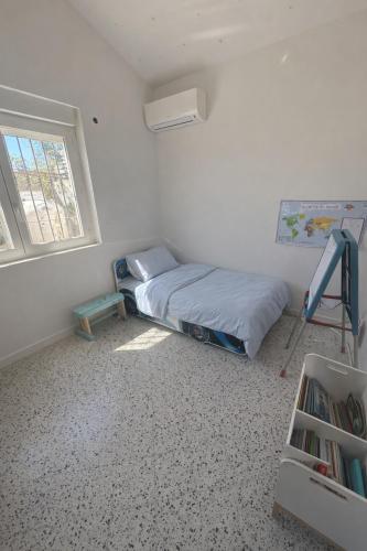 a small bedroom with a bed and a window at La maison de Petit Pierre in Vauvert