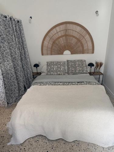 a bedroom with a large white bed in a room at La maison de Petit Pierre in Vauvert