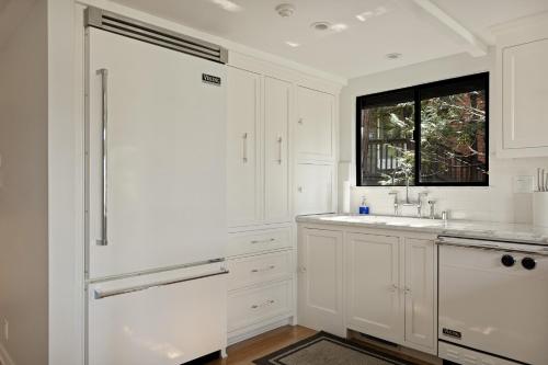 a white kitchen with a sink and a window at The Arrowhead Pearl in Lake Arrowhead
